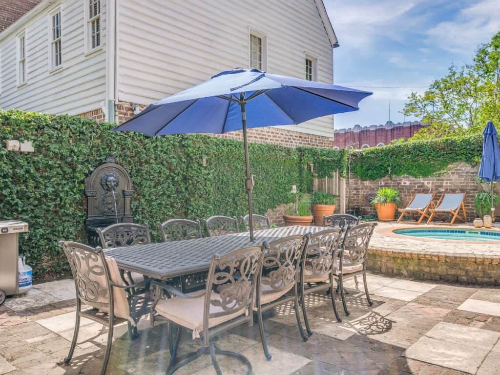hot tub with patio furniture and blue umbrella at dog friendly vacation rental in Savannah