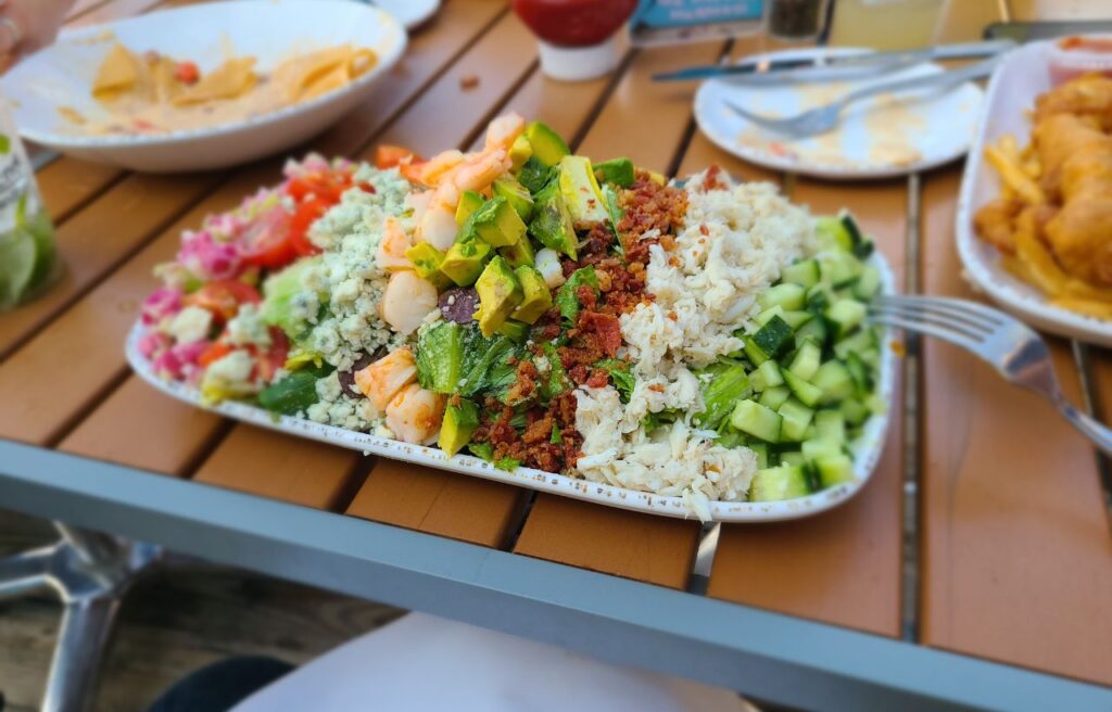 Plate of salad with avocado, cucumber on a patio table
