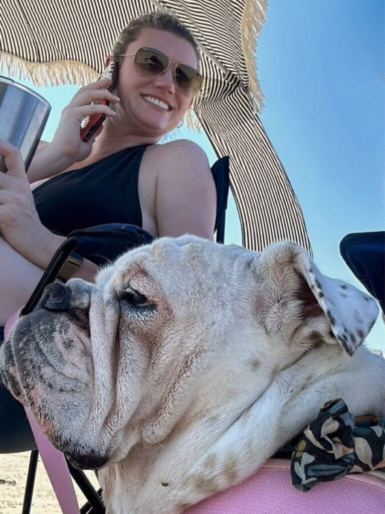 A woman and her bulldog on the beach in Galveston, TX